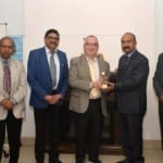 आईएसीबीई के अध्यक्ष डेनिस गैश को स्मृति चिन्ह भेंट करते हुए