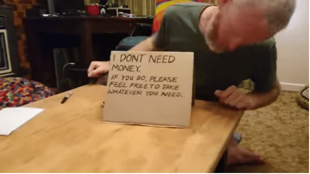 a man like a beggar is providing 100 dollar coin
