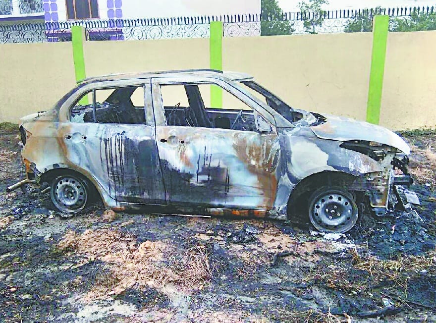 The car parked near a garbage pile burns 