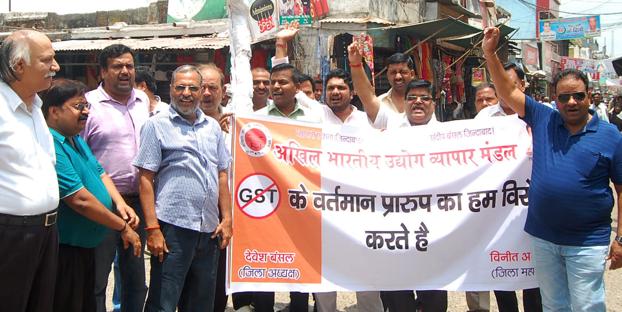 Businessmen blow the effigy of GST