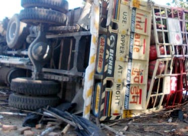 Truck carring LPG cylinder overturns