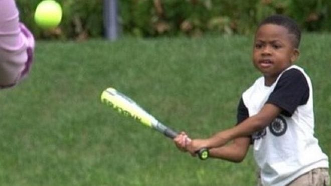 Boy playing baseball with donations