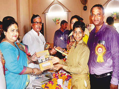 छात्र को नोटबुक देतीं बेसिक शिक्षा राज्यमंत्री अनुपमा जायसवाल।