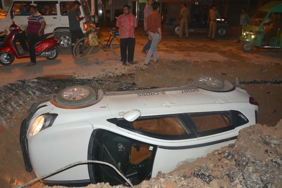 pics of a car falls down in a pit in lucknow 