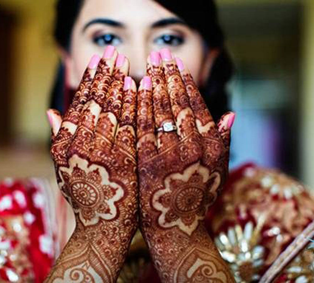 Beautiful woman dressed up as Indian tradition with henna mehndi design on  her both hands to celebrate big festival of Karwa Chauth with plain white b  Stock Photo - Alamy