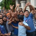 छापेमारी के दौरान नारेबाजी करते लोग