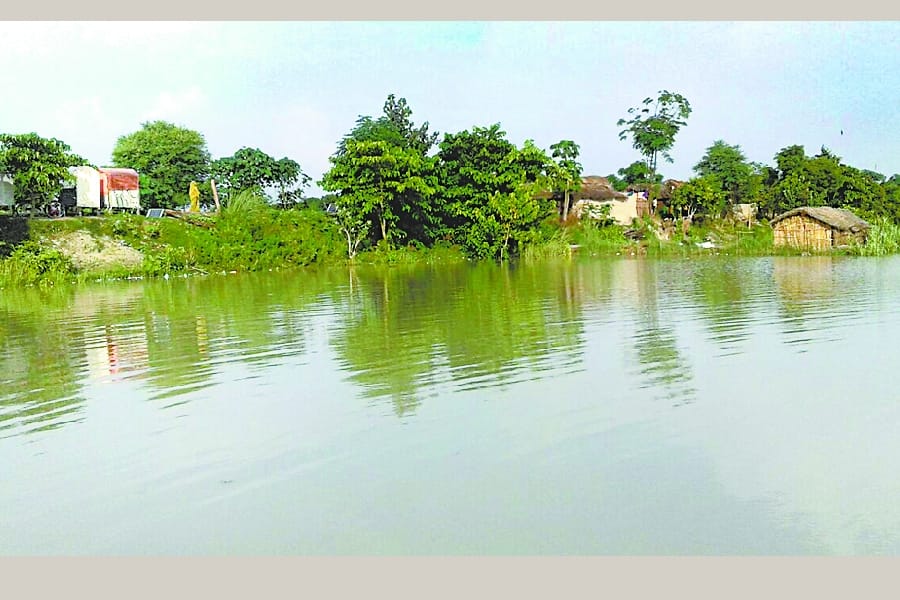 children cross flood water to reach school.
