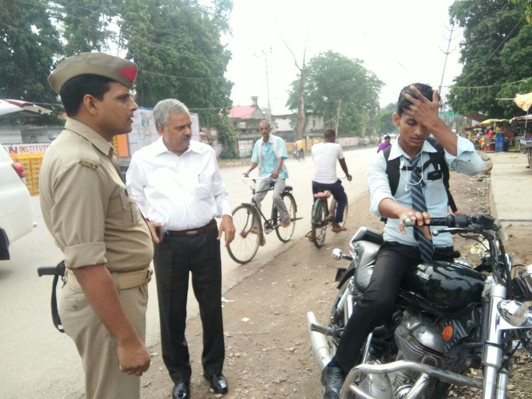 varanasi DM caught a student  without helmet and earphone