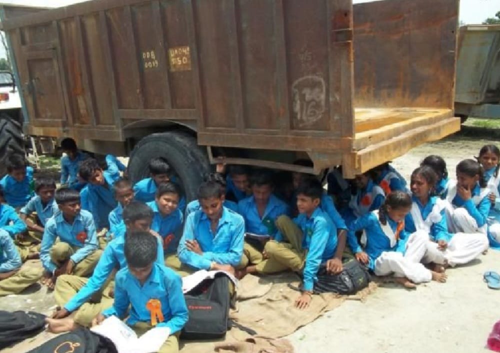students reading in under tractor trolly