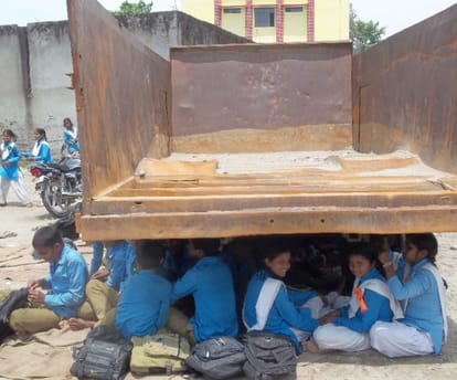 students reading in under tractor trolly