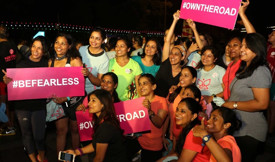 women running on road in cannought place in midnight