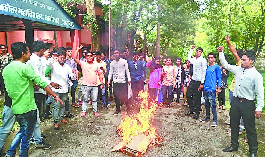 Students hoist the effigy of Higher Education Minister