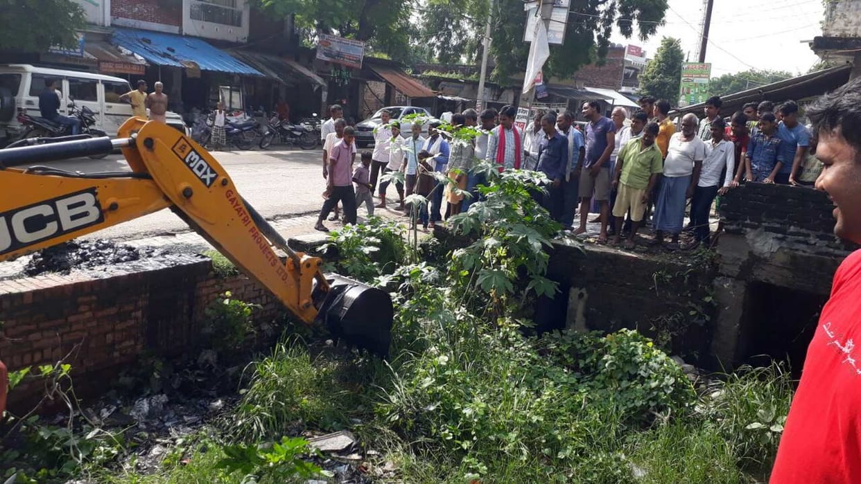 Villagers clean the drainage drain