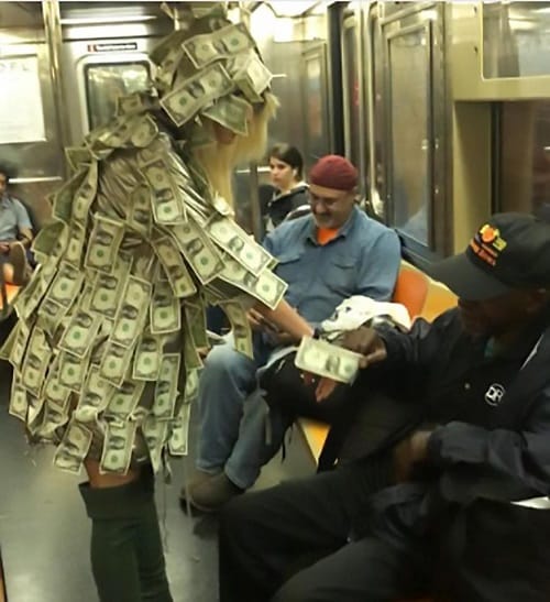 Women wears special dress made of notes asked people to take money in New York Metro