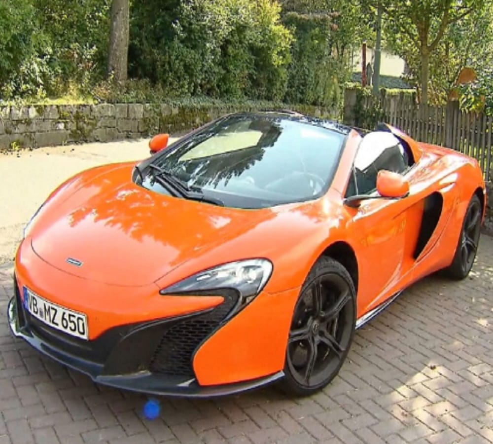 hungry donkey tries to eat carrot coloured mclaren supercar