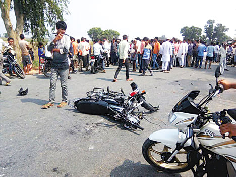 रोड पर पड़ी बाइक और जाम लगाए लोग। 