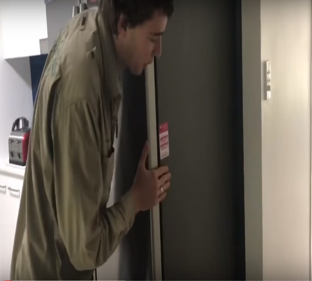 five feet snake crawling under a fridge inside a house
