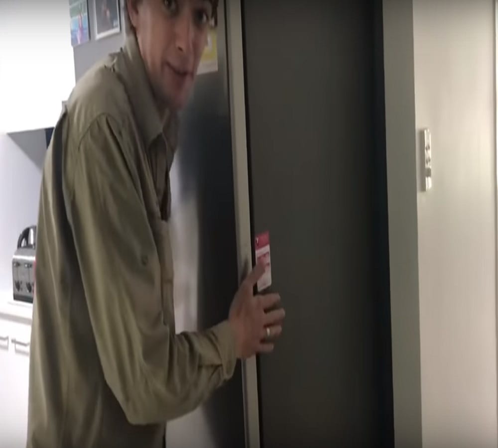 five feet snake crawling under a fridge inside a house