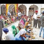 गुरुद्वारा में लंगर छकते श्रद्धालु।