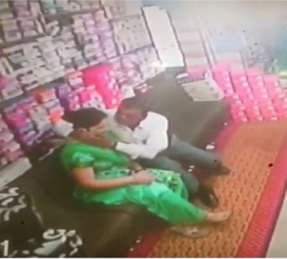 couple kissing scene captured at a footwear shop in CCTV