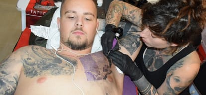 lots of people made tattoo on weekend at tattoo convention
