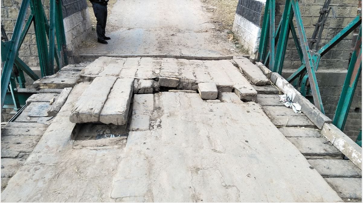 Vehicles are going through a shabby bridge built on the river Tavi