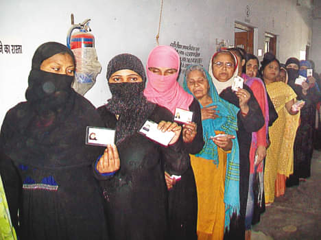 एमआईसी मतदान केंद्र में वोटर आईडी दिखाती महिला