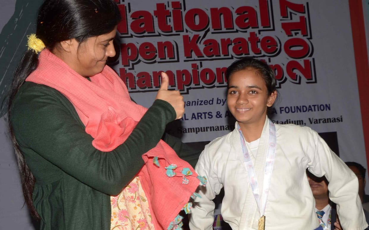 mother father is very happy after his daughter get gold medal in karate