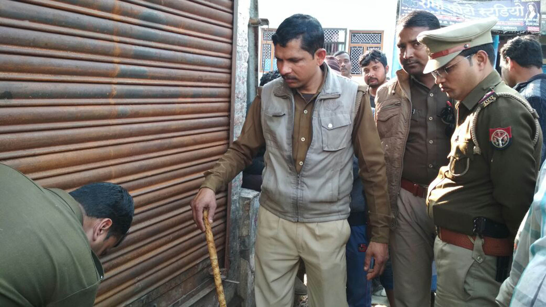 दुकान सील करते पुलिसकर्मी।
