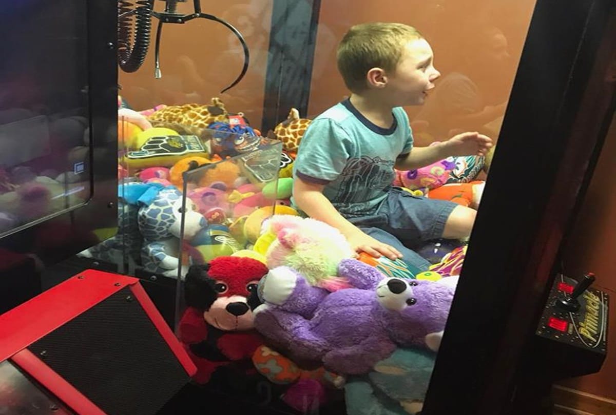 boy climbs into toy claw machine and strucked into it firefighter save him