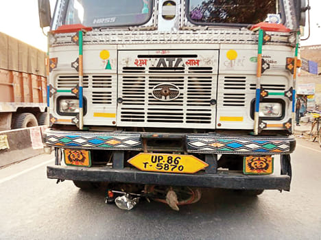  ट्रक के नीचे दबी बिजली मिस्त्री की बाइक।