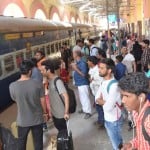 ट्रेन की प्रतीक्षा में स्टेशन पर खड़े यात्री