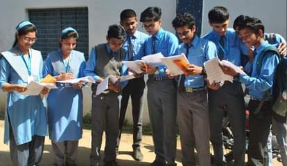 परीक्षा छूटने के बाद पेपर देखते छात्र-छात्राएं।