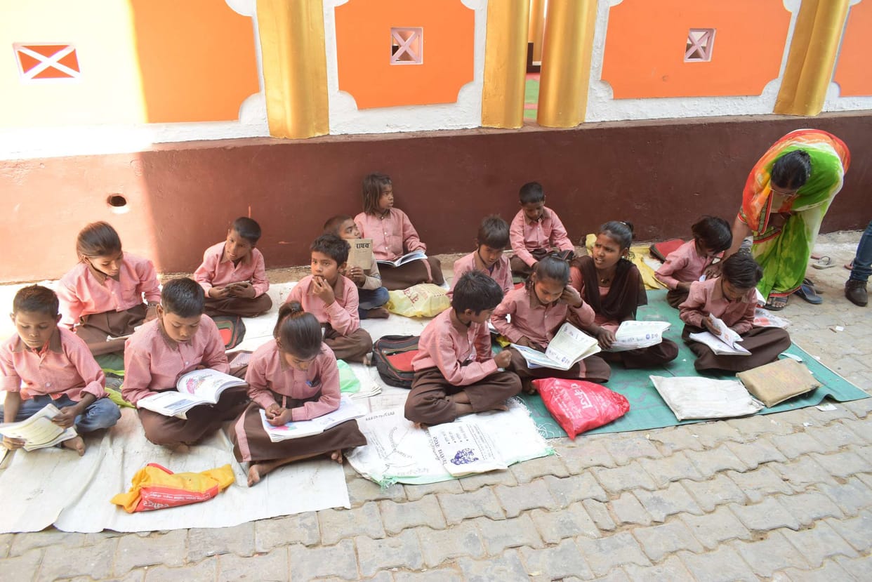 सड़क पर बैठकर परीक्षा दे रहे प्राथमिक विद्यालय के छात्र