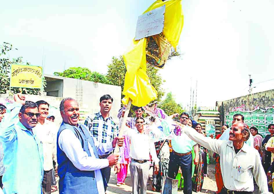 Teachers hoist the effigy of Chief Minister