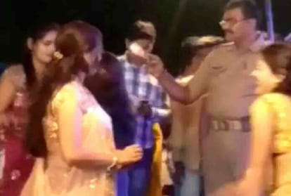 Police personnel throws currency notes at dancers at an event in Unnao