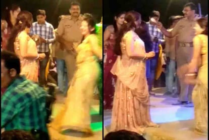 Police personnel throws currency notes at dancers at an event in Unnao
