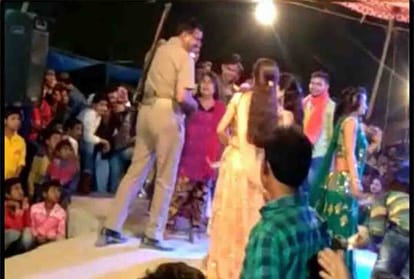 Police personnel throws currency notes at dancers at an event in Unnao