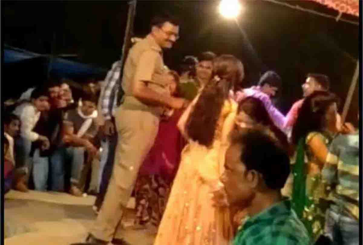 Police personnel throws currency notes at dancers at an event in Unnao