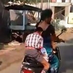son doing homework wiith mother on scooter 