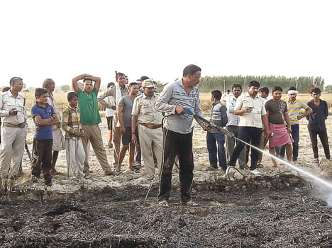  आग को काबू करने में लगे दमकल कर्मचारी और ग्रामीण।
