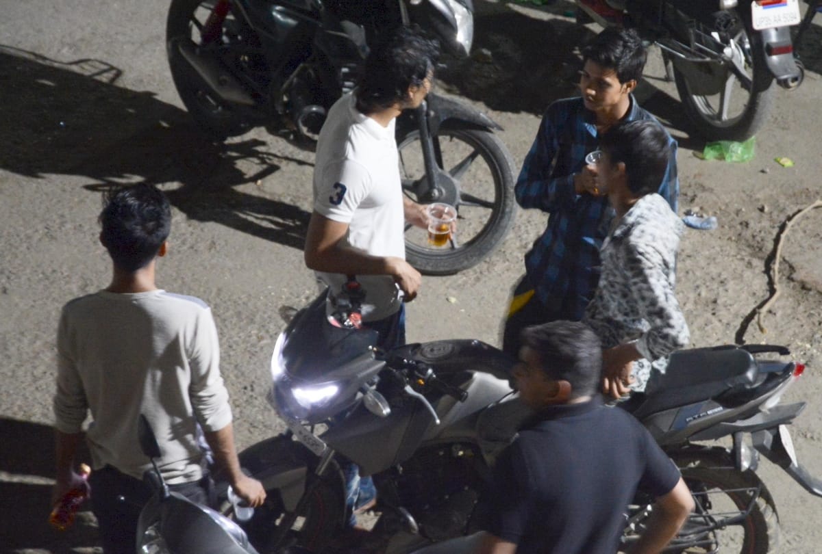 men are drinking wine on road in lucknow