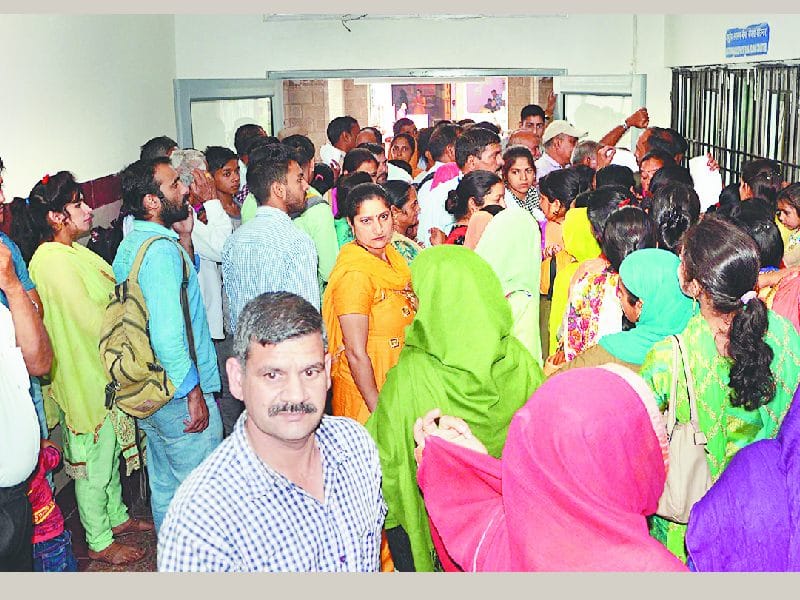 पर्ची कटवाने के लिए धूप और बारिश झेलने को मजबूर मरीज