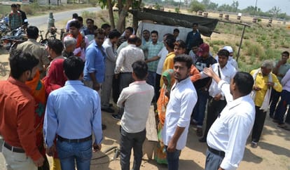 एसपी ऑफिस के पास झुलसे युवक को देखते लोग।