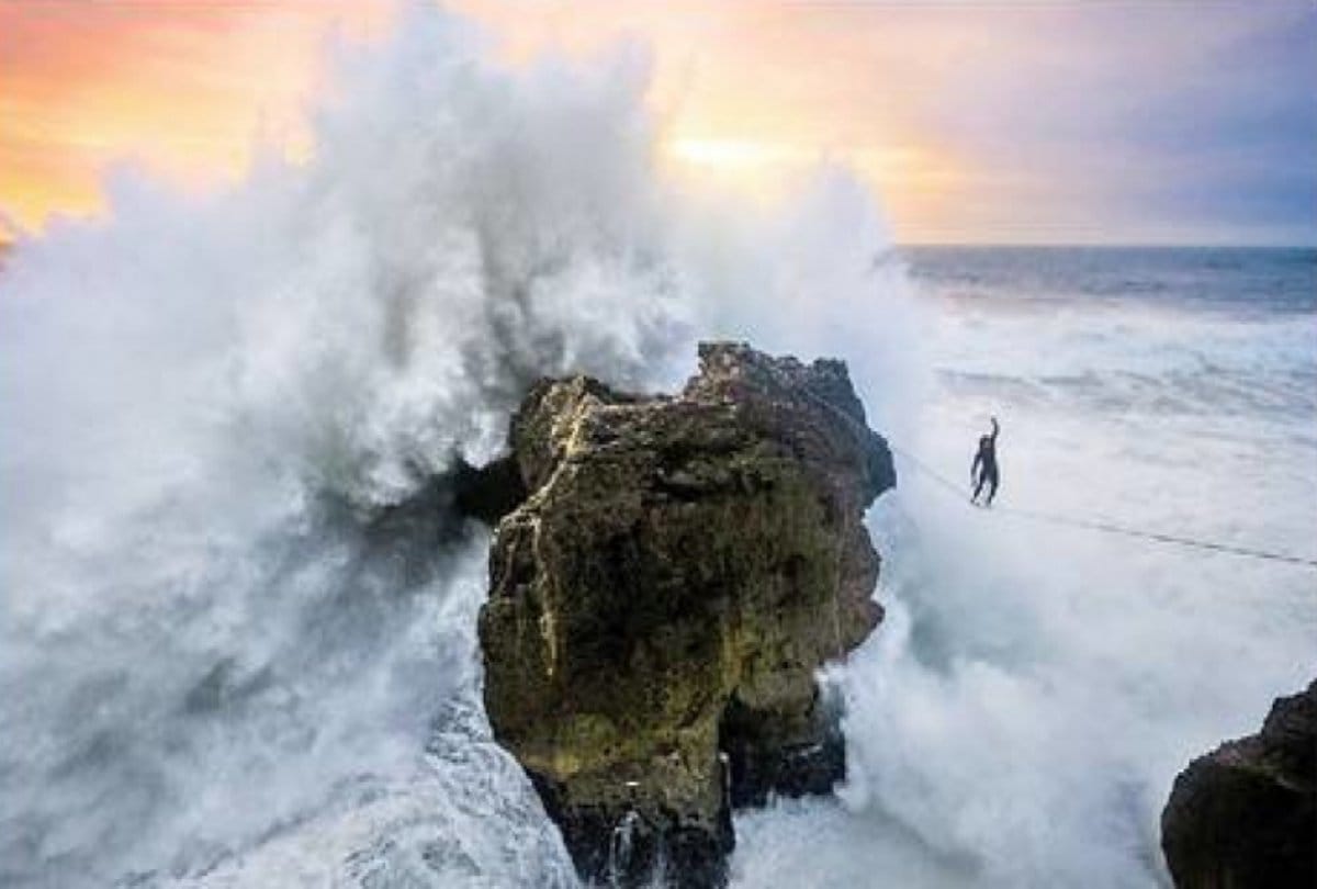 A Daredevil athlete balance between high waves in the storm