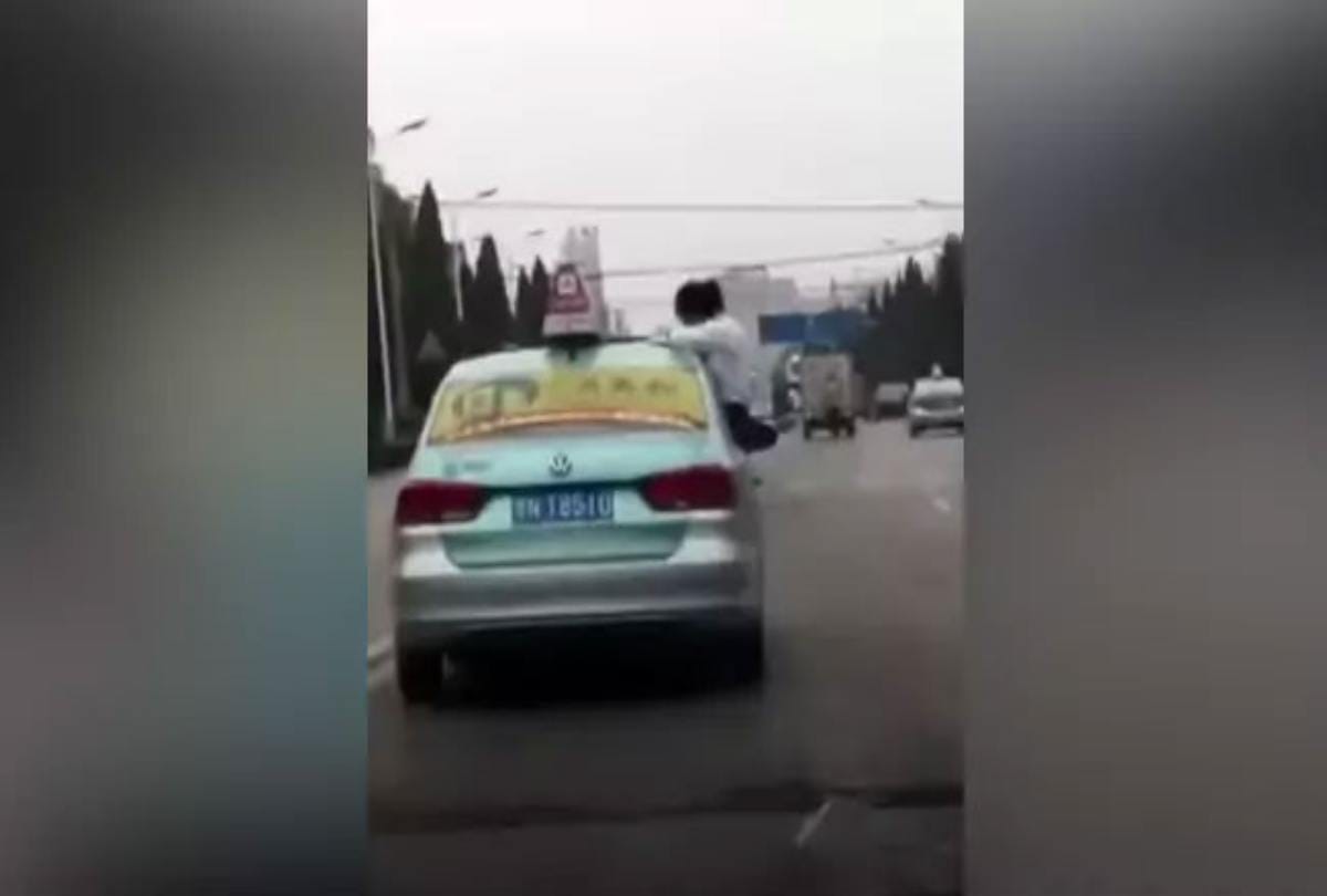 School girl caught doing homework on top speeding taxi roof on china