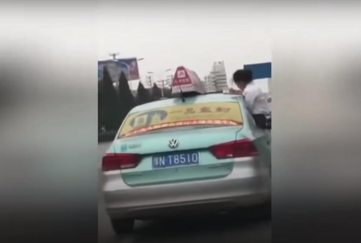 School girl caught doing homework on top speeding taxi roof on china