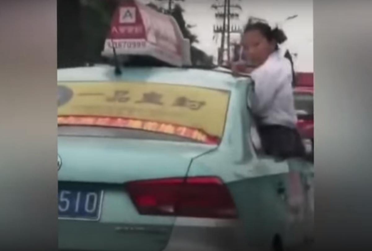 School girl caught doing homework on top speeding taxi roof on china