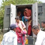 परिवारों को सुरक्षित स्थान पर ले जाती पुलिस