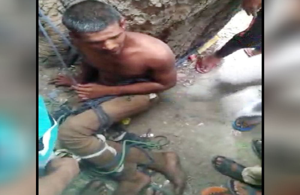 Angry mob beating young man tied to tree for broke God statues